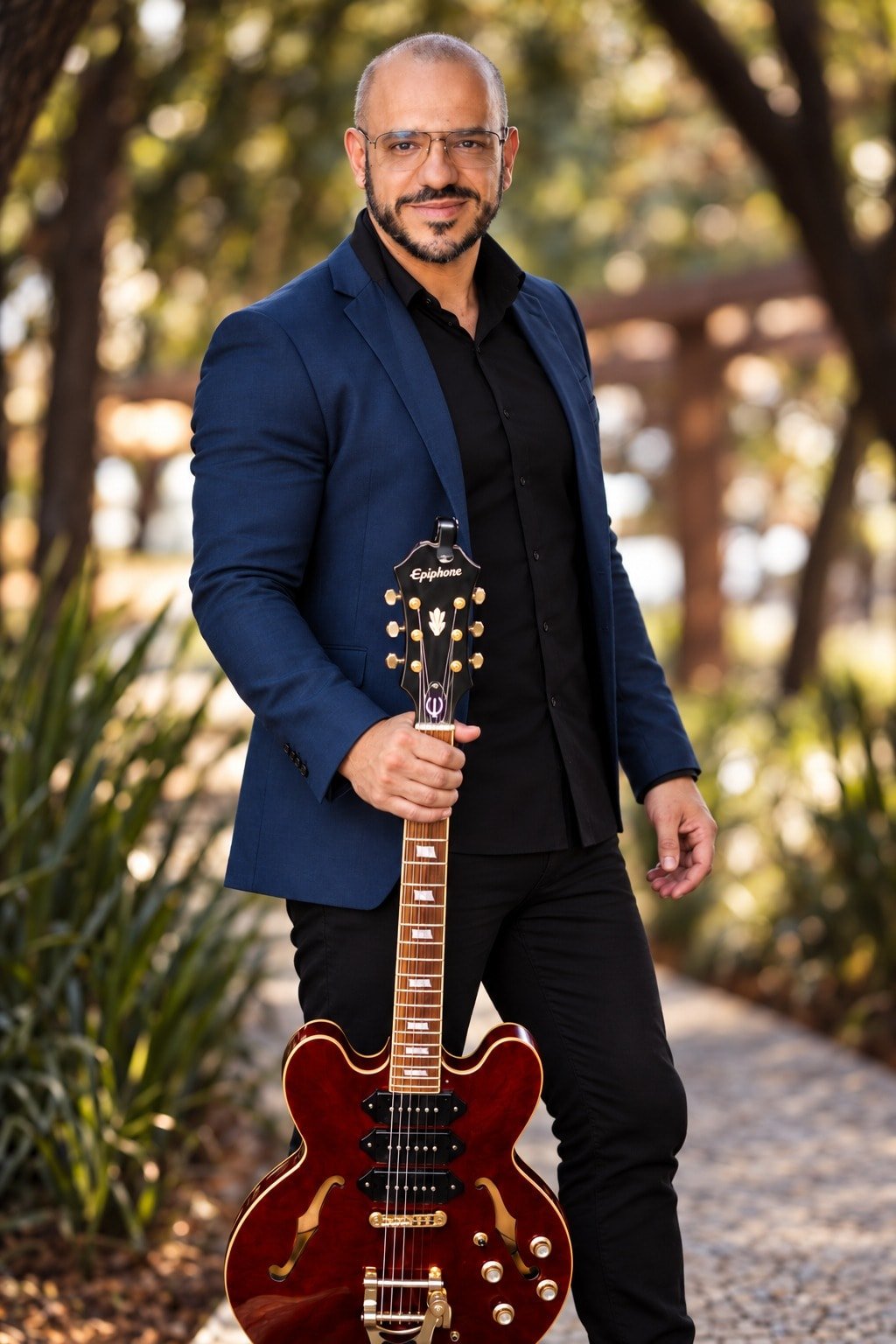 Thiago Azevedo em pé com sua guitarra vermelha